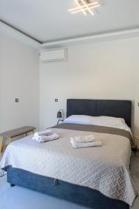 una camera da letto con un letto con due asciugamani sopra di Casa d' Irene near airport, 200 mtrs from the beach, Artemis center a Artemida