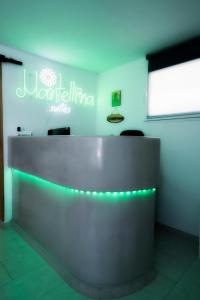 KanalaにあるMantellina Suitesの緑色の照明付きのフロントデスクがあるロビー