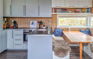 uma cozinha com uma mesa de madeira e um lavatório em Lovely Home In Mykland With House Sea View em Mykland