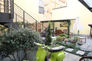 a green scooter parked in a garden at La Casetta B&B in Cernusco sul Naviglio