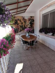 a patio with a table and chairs and flowers at Pensiunea Ca La Mama Acasa in Reşiţa