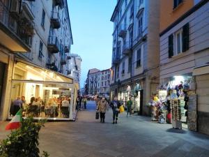 un gruppo di persone che camminano per una strada con negozi di Ca' de Speza a La Spezia