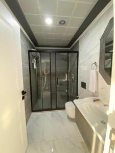 een badkamer met een douche, een toilet en een wastafel bij NENESSAHOTEL in Aksaray