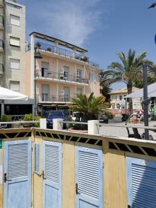un edificio con puertas azules frente a un edificio en Albium - Hotel Sul Mare, en Albenga