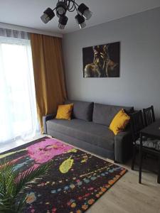 a living room with a couch and a rug at Apartament Letnicka, Nowy, 950m od morza in Gdańsk