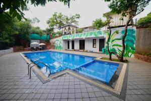 a swimming pool in front of a building at Tranquil Resort & Spa in Mahabaleshwar