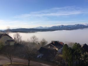 a view of a foggy valley with mountains in the background at Haus Seeberghof by Globalimmoservice in Millstatt +8 photos