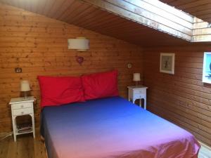 een slaapkamer met een bed met rode kussens en 2 tafels bij Haus Seeberghof by Globalimmoservice in Millstatt