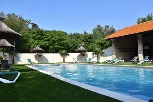 a swimming pool with lawn chairs and umbrellas at CAMPING SAINT GABRIEL *** in Tarascon