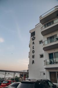 a hotel with cars parked in front of it at Hotel Aloha in Sarandë