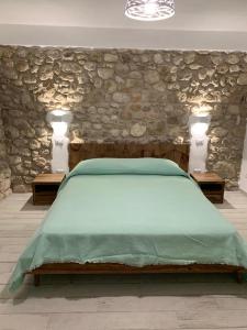 1 dormitorio con 1 cama con pared de piedra en LA CASA DI PIETRA, en Formia