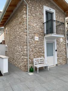 a bench sitting in front of a stone building at LA CASA DI PIETRA in Formia