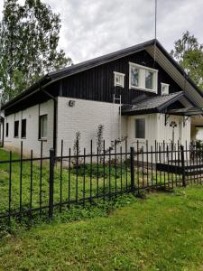 a white house with a fence in front of it at Omenapolun Onni in Taipalsaari