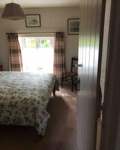a bedroom with a bed and a window at Lovely Cornish cottage in small village setting in Saint Hilary