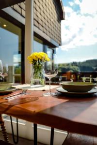 a wooden table with a glass of wine on it at Sonnen Panorama - Abenteurer und Weltentdecker in Winterberg