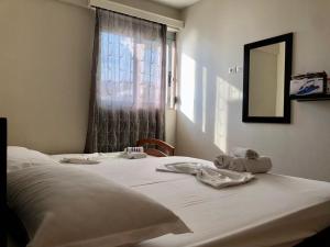 a bedroom with a bed with a mirror and a window at Lorenso Guest House in Sarandë