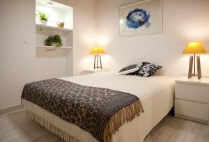 een slaapkamer met een groot bed met 2 lampen bij Authentic Charming Apartment/Wifi/Air Conditioning in Valencia