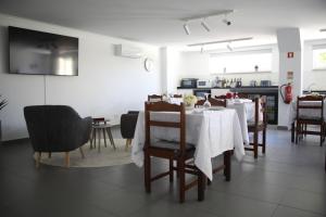 a dining room with a white table and chairs at Quinta Vale de Palheiros in Santa Comba Dão