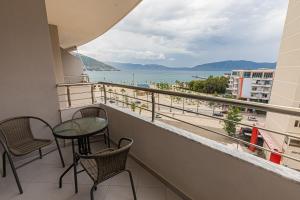 balcón con mesa, sillas y vistas al océano en NOVUS ROOMS, en Vlorë