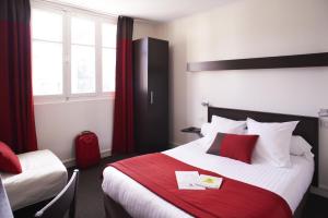 une chambre d'hôtel avec un lit et une couverture rouge dans l'établissement Logis Hotel Chateaubriand, à Nantes