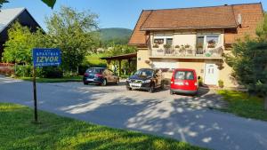 a house with cars parked on the side of the road at Izvor in Ogulin