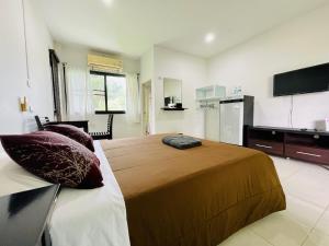 a bedroom with a large bed and a kitchen at Wassana Sitdharma Guesthouse in Ban Na Pho