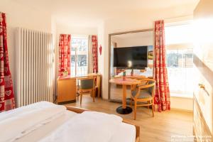 Pokój hotelowy z łóżkiem, stołem i telewizorem w obiekcie Hotel Oberwirt Wangen w mieście Wangen im Allgäu