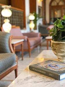 a book sitting on top of a table with a plant at Syrou Melathron in Ermoupoli