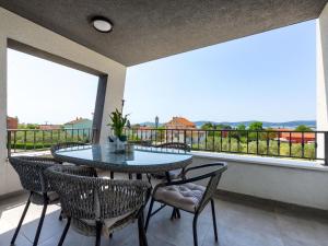 a patio with a table and chairs on a balcony at Modern villa in Sveti Filip with pool in Sveti Filip i Jakov