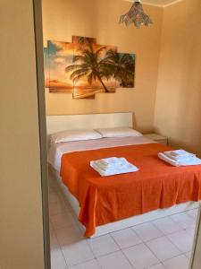 una camera con un letto e una coperta arancione di A Casa di Antonio 1 a Scalea