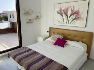 Villa de 2022 moderna y con piscina privada في سان بييدرو ديل بيناتار: غرفة نوم بسرير كبير ومخدة ارجية