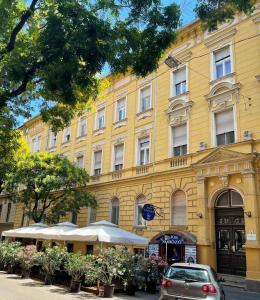 a car parked in front of a yellow building at Biztos Kuckó in Szeged