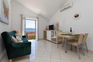 a living room with a table and a chair and a dining room at Apartments Paloc - Green in Bol