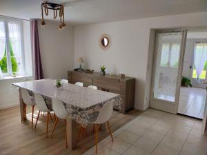 a dining room with a table and white chairs at Gîte Chez Cheynaud in Celles