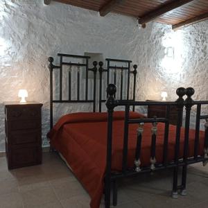 a bedroom with a black bed and a dresser with a table at Le Casette casa vacanze in Parabita