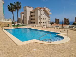 ein Schwimmbad vor einem Gebäude in der Unterkunft Stunning sea views at just 270 m from the beach in Arenales del Sol