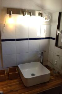a white sink in a bathroom with a light at LE PIGEONNIER Ajaccio in Ajaccio
