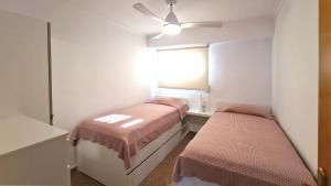 ein kleines Schlafzimmer mit 2 Betten und einem Spiegel in der Unterkunft Stunning sea views at just 270 m from the beach in Arenales del Sol + 15 Fotos