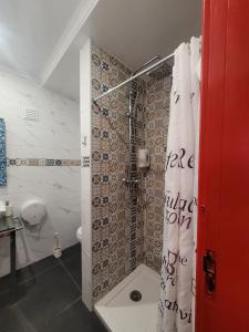 een badkamer met een douche en een douchegordijn bij Casa de Porto Covo Guest House in Porto Covo