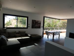 a living room with a couch and a table with chairs at Résidence Les Jardins du Fort in Porticcio