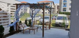 a patio with a gazebo and a table and chairs at Tecoma Rooms Mamaia in Mamaia Sat/Năvodari