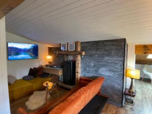 uma sala de estar com um sofá e uma parede de tijolos em Appartement en plein centre du village (6-8 personnes) em Les Contamines-Montjoie