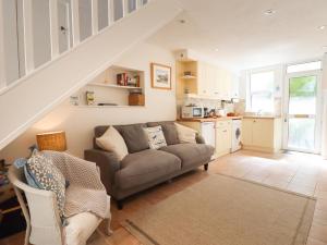 a living room with a couch and a kitchen at Quayside Cottage in Teignmouth