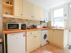 a kitchen with a microwave and a washer and dryer at Quayside Cottage in Teignmouth +16 photos