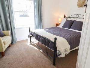 a bedroom with a bed and a window at Quayside Cottage in Teignmouth