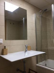 MAGNIFICO APARTAMENTO EN GARBI con Aire Acondicionado في بينييسكولا: حمام مع حوض ومرآة وحوض استحمام