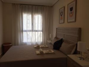 - une chambre avec un lit, 2 chaussons et une fenêtre dans l'établissement MAGNIFICO APARTAMENTO EN GARBI con Aire Acondicionado, à Peñíscola