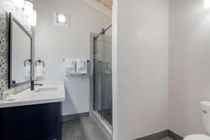 a bathroom with a shower and a sink and a mirror at Comfort Inn Carmel By the Sea in Carmel