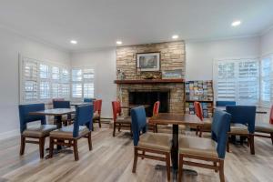 a restaurant with tables and chairs and a fireplace at Comfort Inn Carmel By the Sea in Carmel