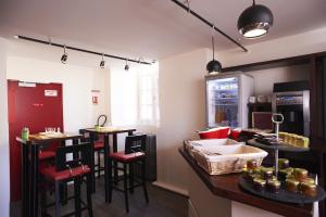 une cuisine avec un bar avec des tabourets et un comptoir dans l'établissement Logis Hotel Chateaubriand, à Nantes